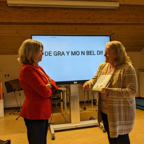 Gerlinde Wright überreicht Frau Moroder als Dankeschön unser Buch "Eine Klasse - zwei Sprachen"